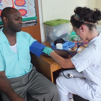 A teenage intern measures a local man's blood pressure during a community outreach in Jamaica. A Jamaican patient has his blood pressure levels measured by a teenage Public Health intern during a medical outreach.